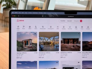Laptop screen displaying Airbnb listings for short-term rental properties in California